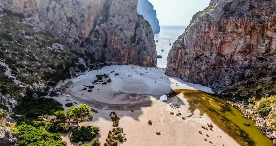 Luftaufnahme des Torrent de Pareis Strands umgeben von Steilklippen bei Sa Calobra, Mallorca